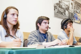 students wearing headphones sitting on a panel